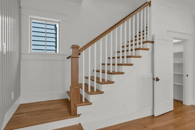 a view of a hallway with wooden floor and staircase