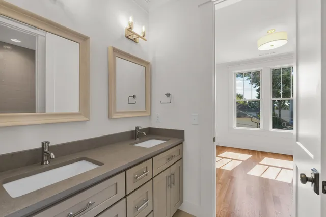 a view of a hallway to a room with wooden floor and cabinet