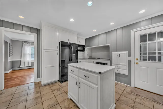 a kitchen with white cabinets and stainless steel appliances