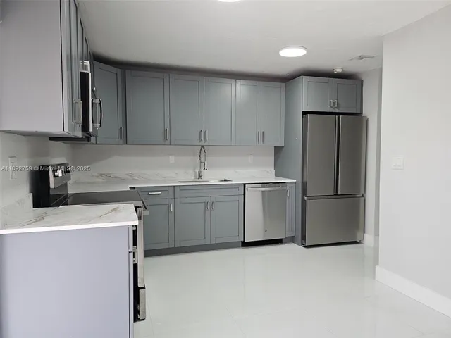 a kitchen with a sink a refrigerator and cabinets