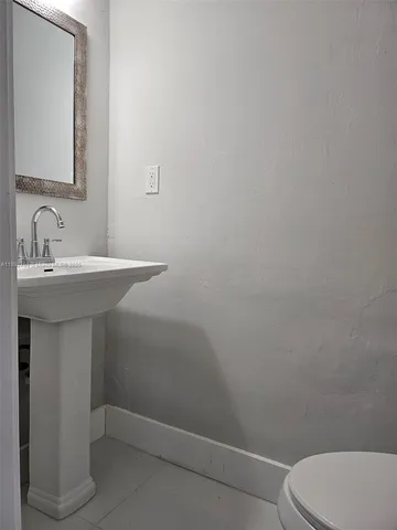 a bathroom with a sink a toilet and mirror