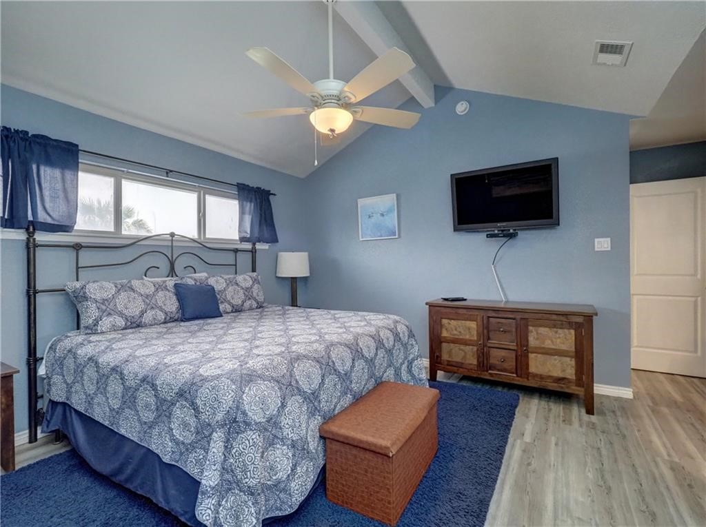 715 Beach Access Road, Unit 1204 Port Aransas, TX 78373 - Photo 14 of 33 a bedroom with a bed a couch and a flat screen tv