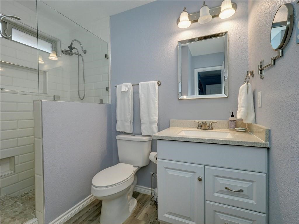 715 Beach Access Road, Unit 1204 Port Aransas, TX 78373 - Photo 17 of 33 a bathroom with a granite countertop sink toilet and shower