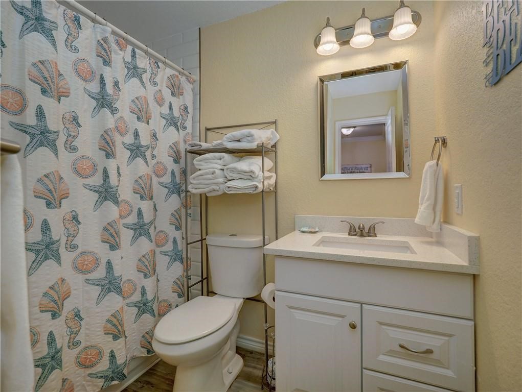 715 Beach Access Road, Unit 1204 Port Aransas, TX 78373 - Photo 25 of 33 a bathroom with a granite countertop sink toilet and mirror
