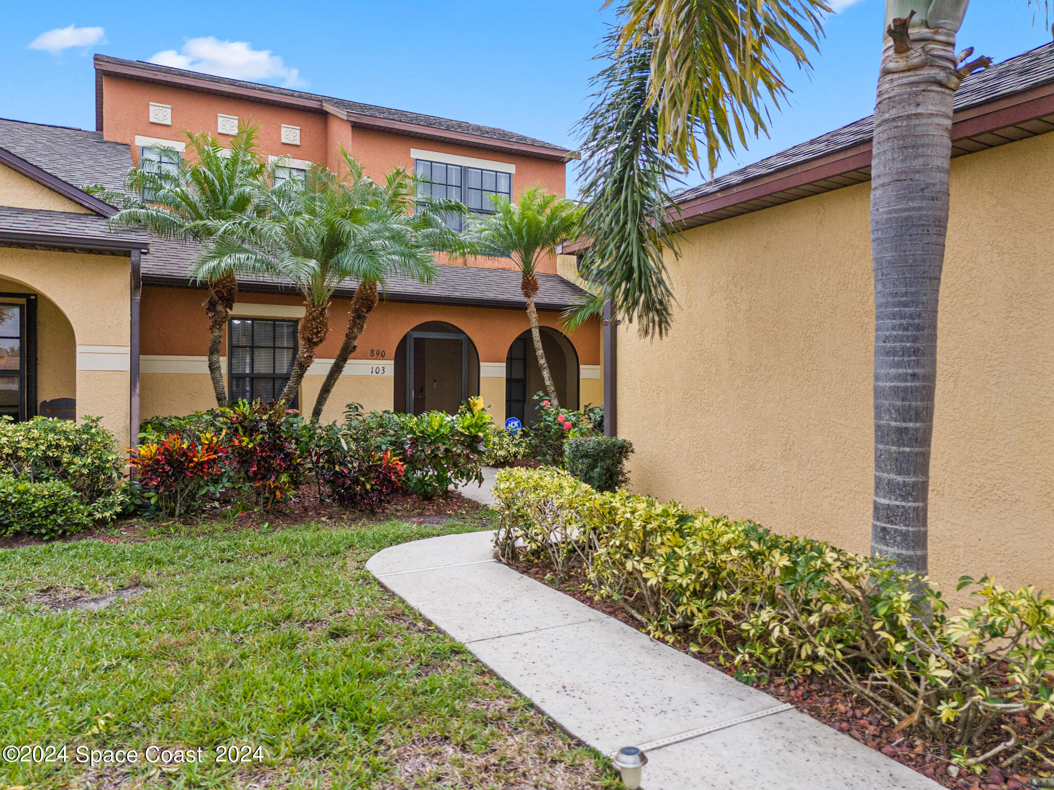 890 Luminary Circle, Unit 103 Melbourne, FL 32901 - Photo 1 of 32 a front view of a house with a garden