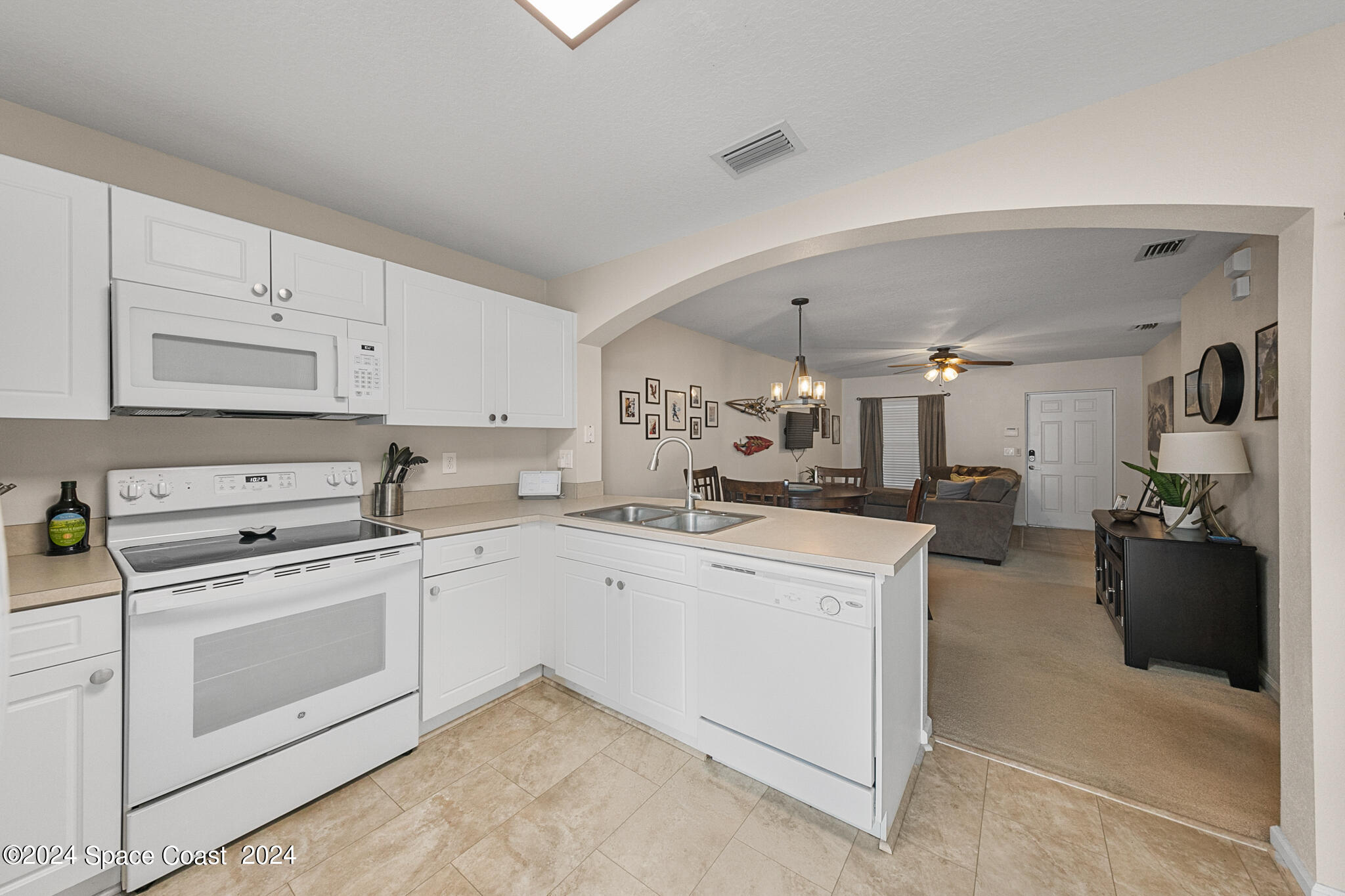 890 Luminary Circle, Unit 103 Melbourne, FL 32901 - Photo 12 of 32 a kitchen with a stove top oven and cabinets