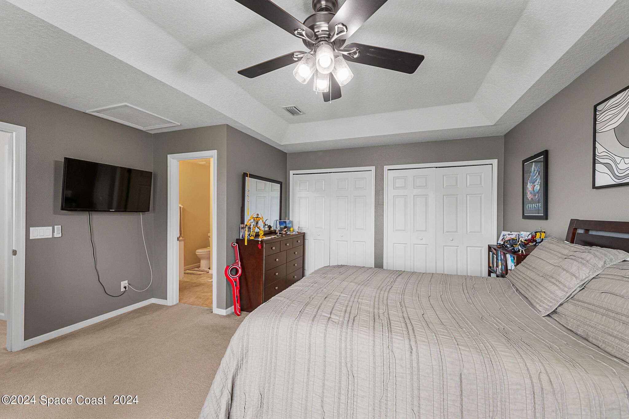 890 Luminary Circle, Unit 103 Melbourne, FL 32901 - Photo 18 of 32 a bedroom with a bed and a flat screen tv