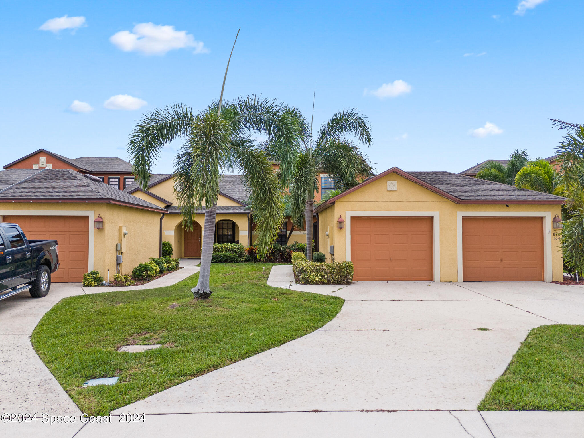890 Luminary Circle, Unit 103 Melbourne, FL 32901 - Photo 3 of 32 a front view of a house with a yard and garage