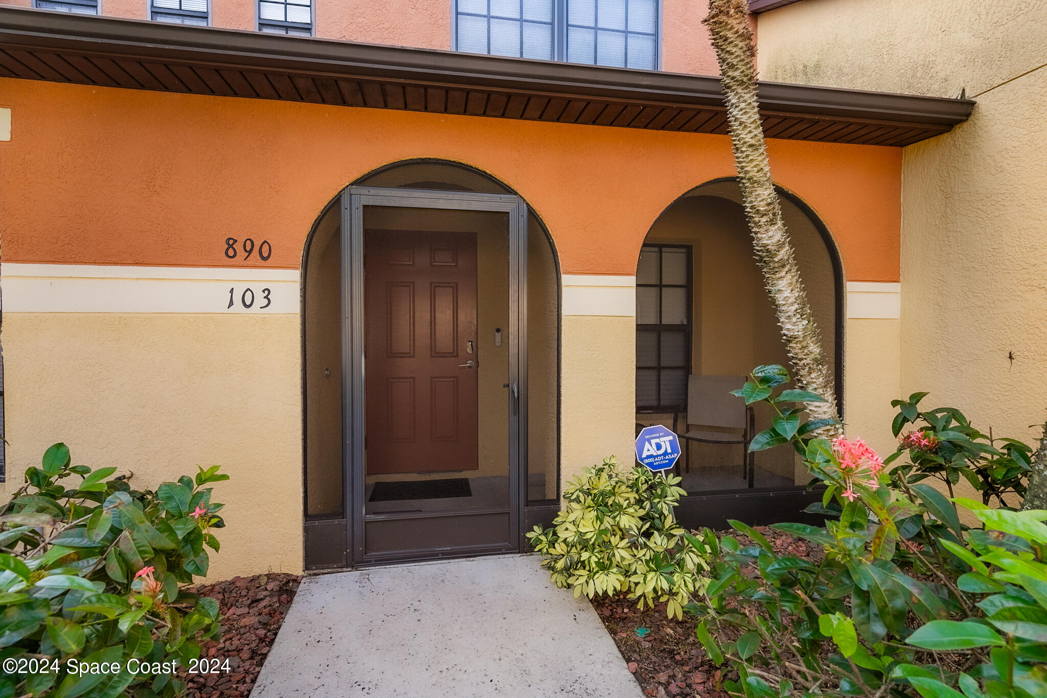 890 Luminary Circle, Unit 103 Melbourne, FL 32901 - Photo 4 of 32 a front view of a house with flower plants