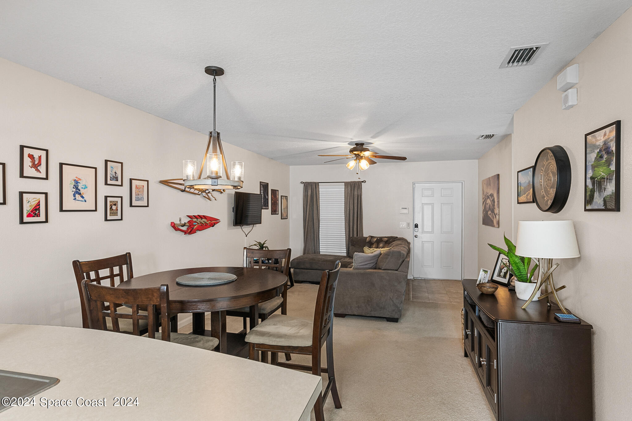 890 Luminary Circle, Unit 103 Melbourne, FL 32901 - Photo 6 of 32 a living room with furniture and a chandelier