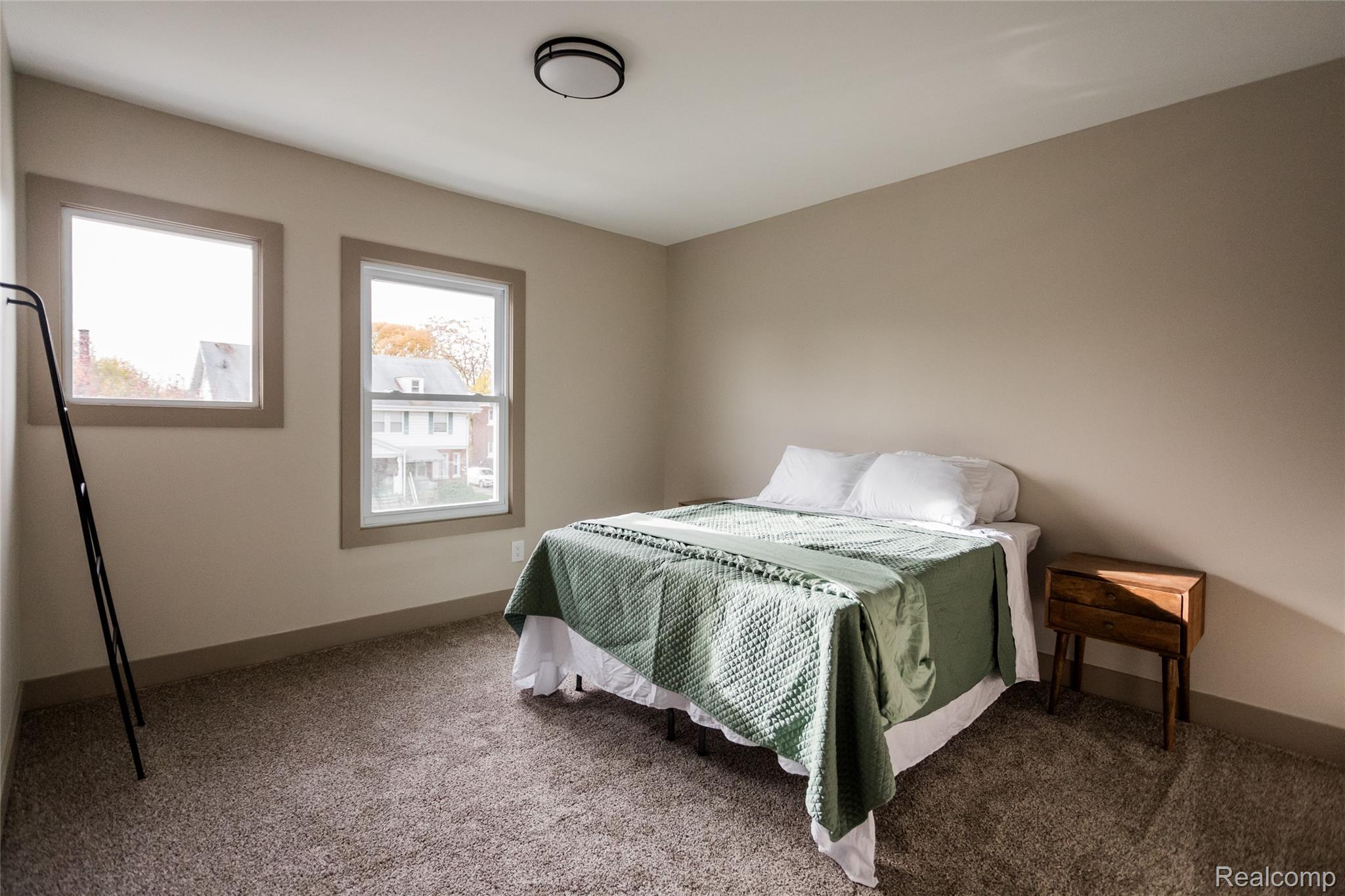 2630 Harding Street Detroit, MI 48214 - Photo 24 of 30 Carpeted bedroom with two windows featuring neutral-toned walls and trim, and a flush mount ceiling light fixture