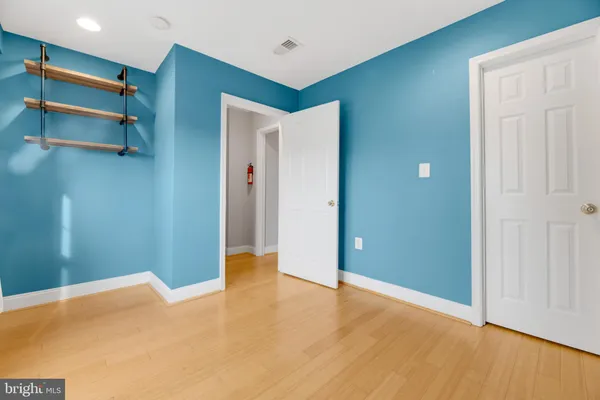 an empty room with closet and a chandelier fan
