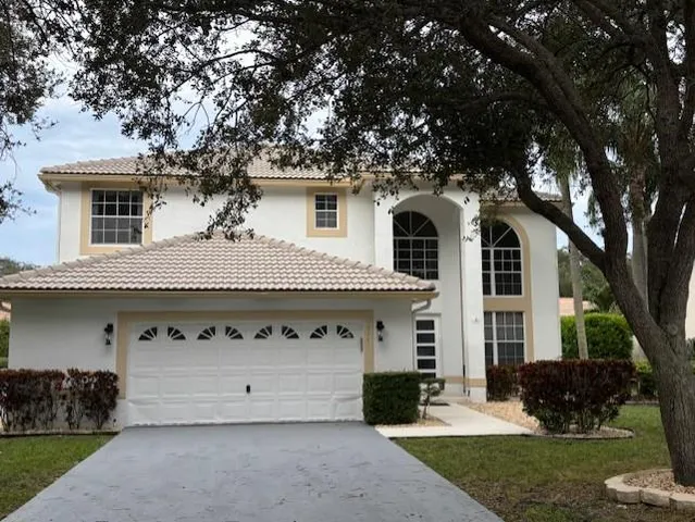 a front view of a house with a garden and trees
