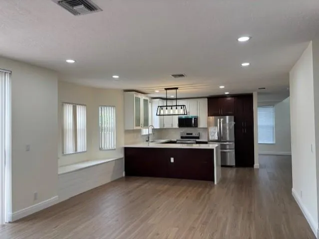 a kitchen with kitchen island granite countertop stainless steel appliances stove sink and refrigerator