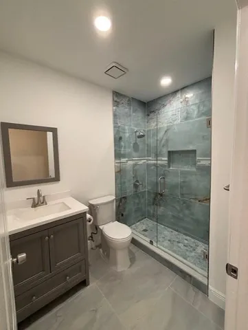 a bathroom with a double vanity sink toilet and shower