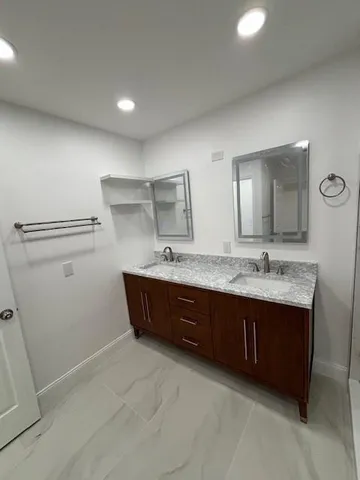 a bathroom with a granite countertop sink and mirror