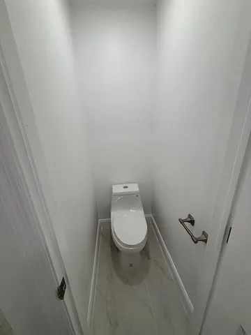 a white toilet sitting next to a white sink