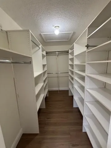 a view of walk in closet with empty racks