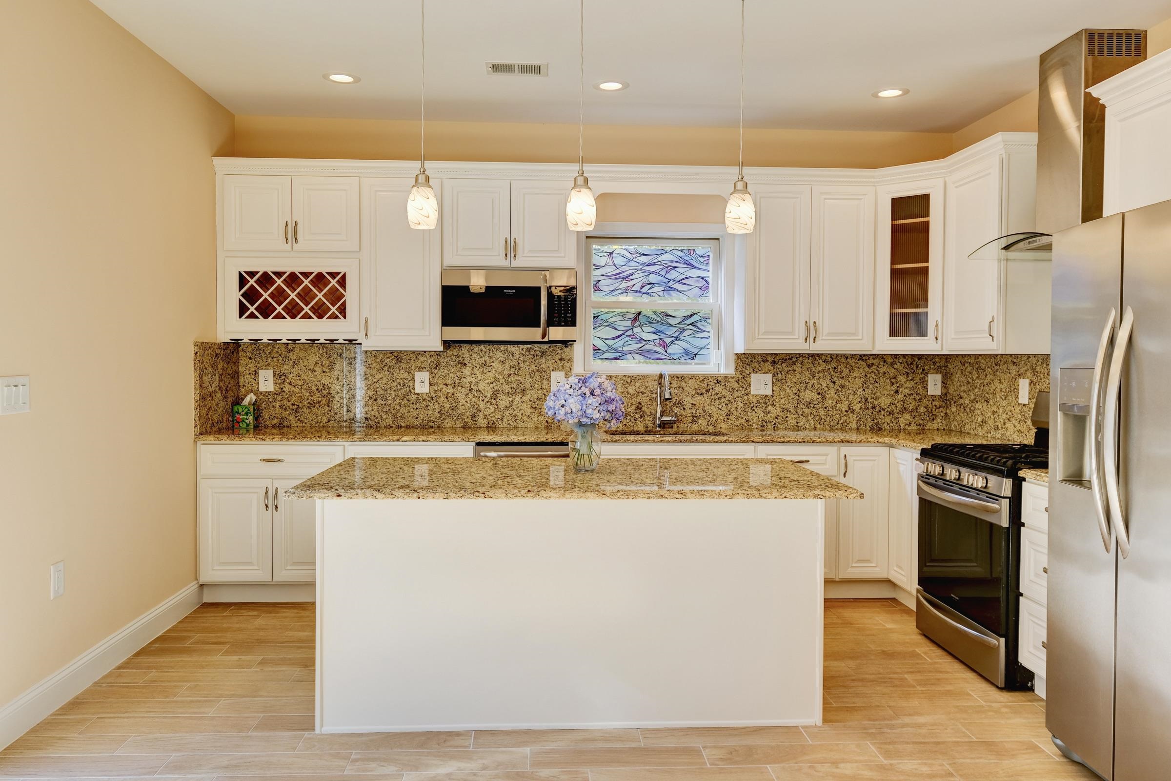 726 Chestnut Street, Unit B Secaucus, NJ 07094 - Photo 13 of 50 a kitchen with kitchen island granite countertop a stove and a sink