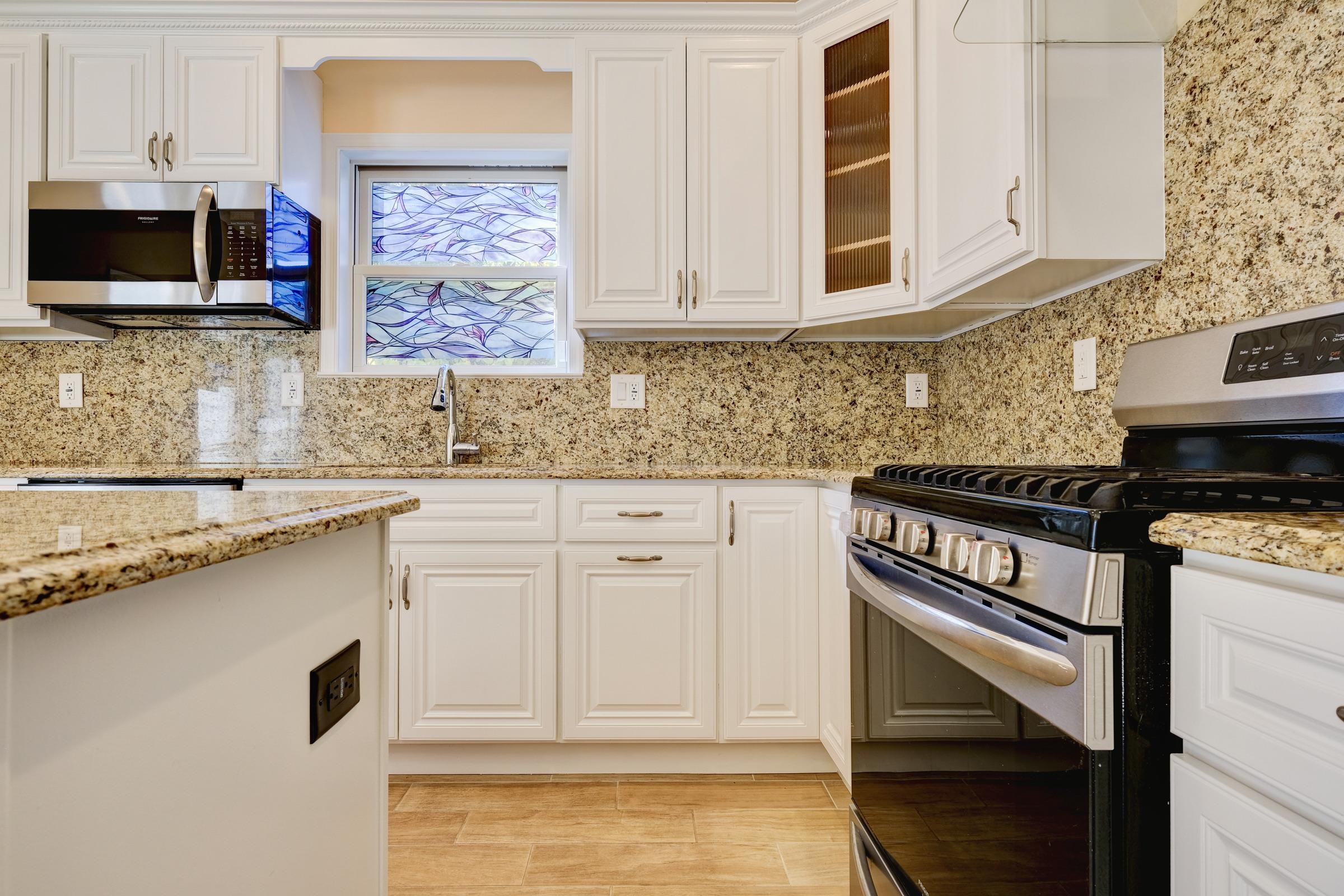 726 Chestnut Street, Unit B Secaucus, NJ 07094 - Photo 17 of 50 a kitchen with stainless steel appliances granite countertop a stove a sink and a microwave