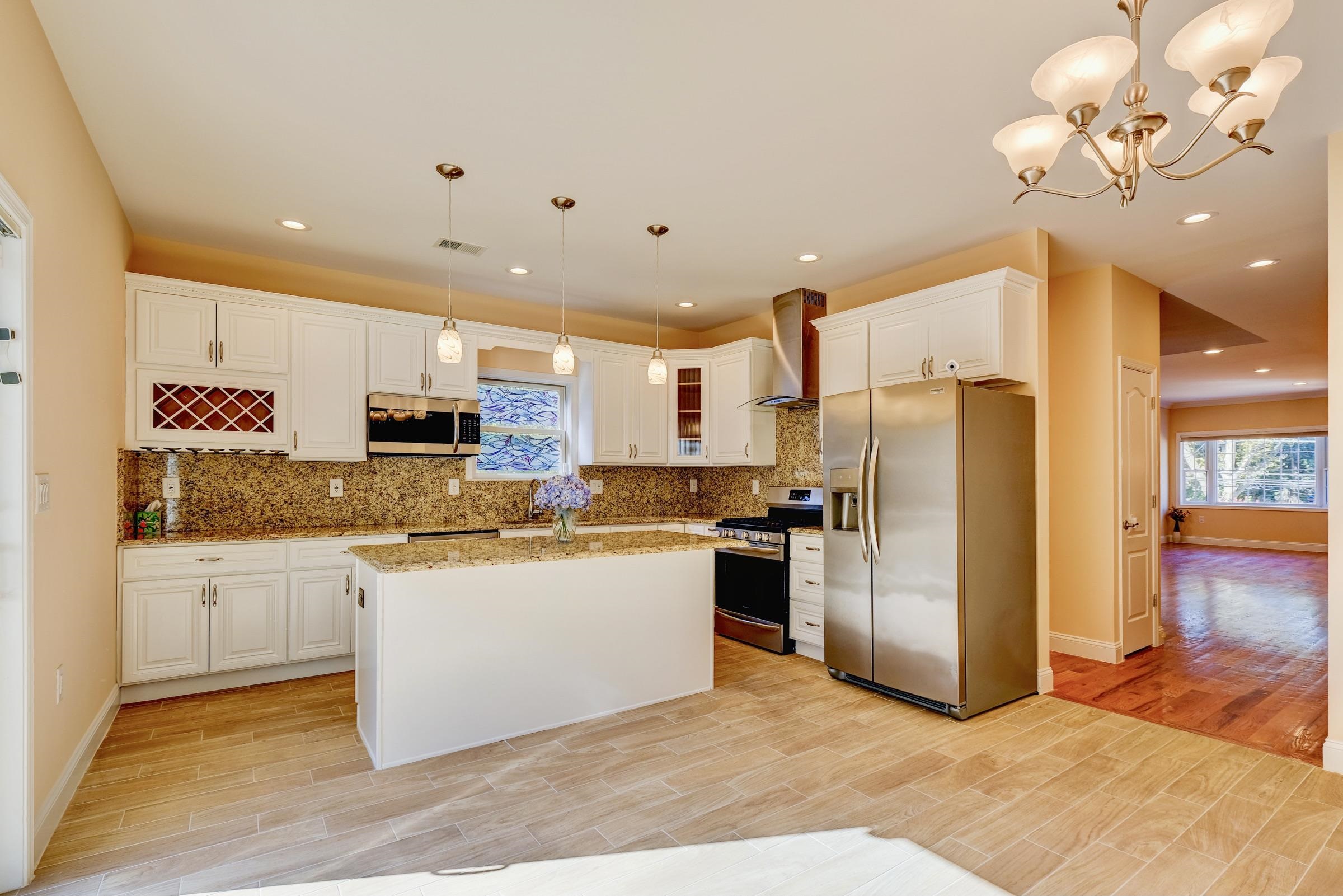 726 Chestnut Street, Unit B Secaucus, NJ 07094 - Photo 10 of 50 a kitchen with stainless steel appliances granite countertop a refrigerator a stove top oven a sink and dishwasher with wooden floor