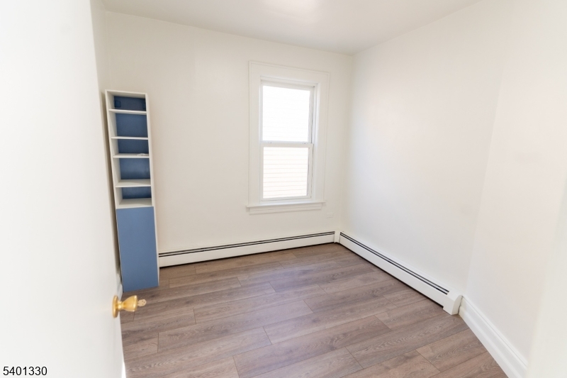 123 Clark Place Elizabeth Port, NJ 07206 - Photo 7 of 17 an empty room with wooden floor and window