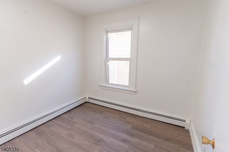 123 Clark Place Elizabeth Port, NJ 07206 - Photo 9 of 17 an empty room with wooden floor and windows