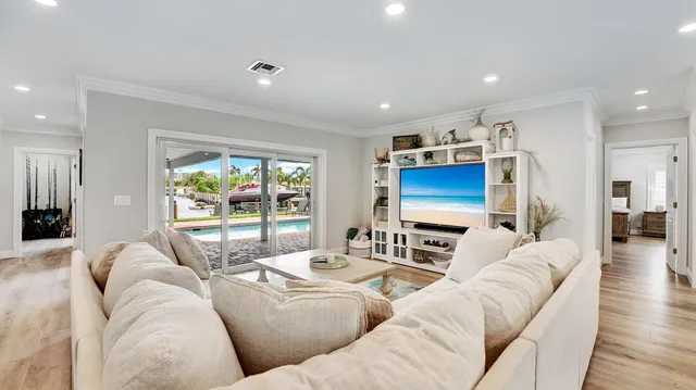 a living room with furniture flat screen tv and a large window