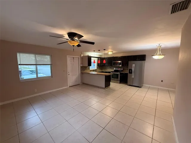 a kitchen with stainless steel appliances granite countertop a refrigerator and a stove top oven