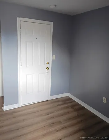 a view of an empty room with wooden floor