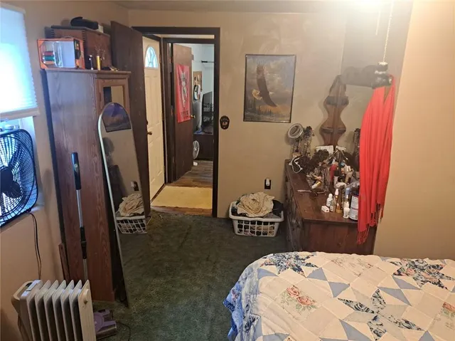 a bedroom with a bed and a large mirror on the dresser