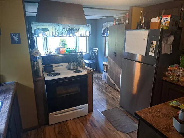 a kitchen with stainless steel appliances granite countertop a refrigerator a stove and a sink