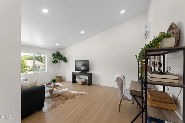 a living room with furniture a window and a flat screen tv