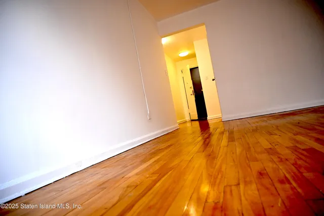 a view of a room with wooden floor and a bathroom