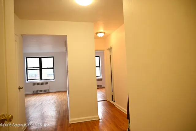 a view of a room with wooden floor and windows