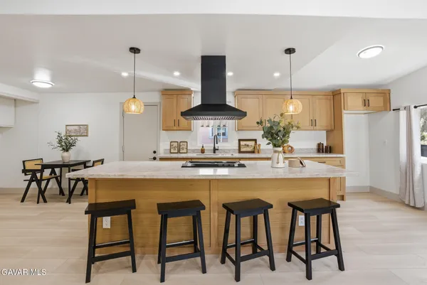 a kitchen with stainless steel appliances a dining table chairs and white cabinets