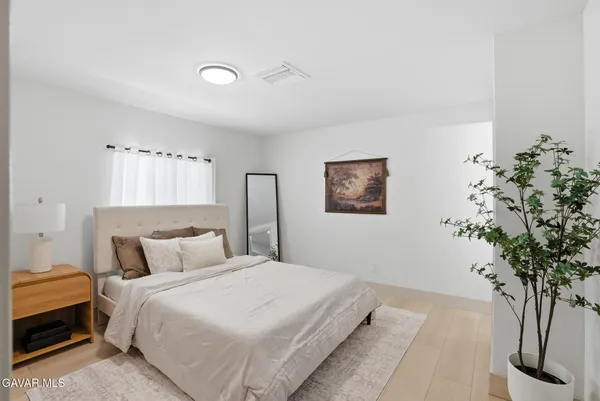 a bedroom with a large bed and a potted plant