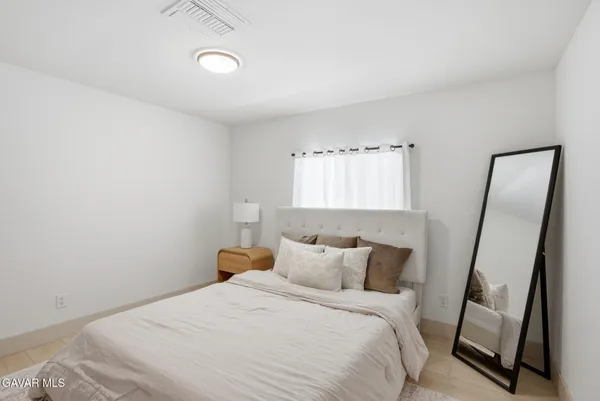 a bedroom with a bed and a mirror