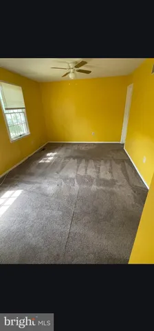 a view of an empty room with a ceiling fan