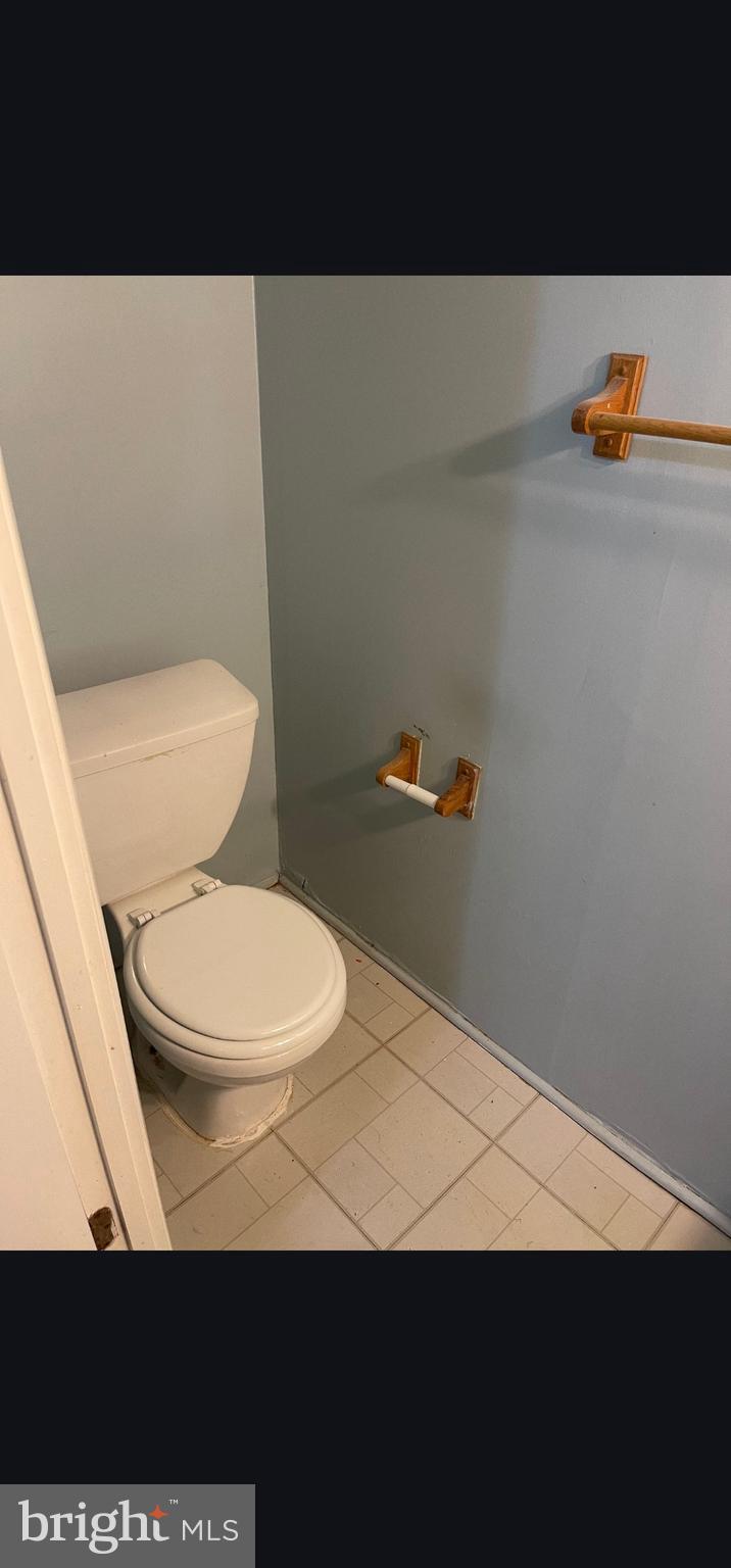 822 Joshua Tree Court Owings Mills, MD 21117 - Photo 19 of 27 a bathroom with a toilet and a wooden floor