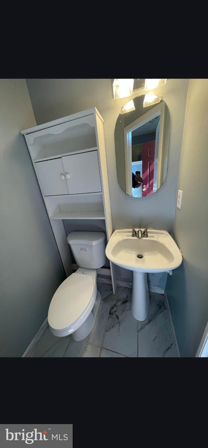 822 Joshua Tree Court Owings Mills, MD 21117 - Photo 21 of 27 a bathroom with a toilet a sink and a mirror