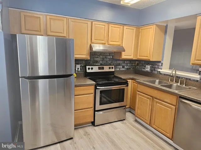 a kitchen with a refrigerator stove and sink