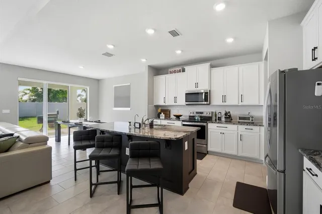 a kitchen with appliances cabinets and furniture