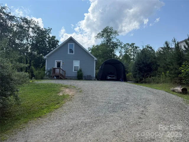 a front view of a house with a yard and trees