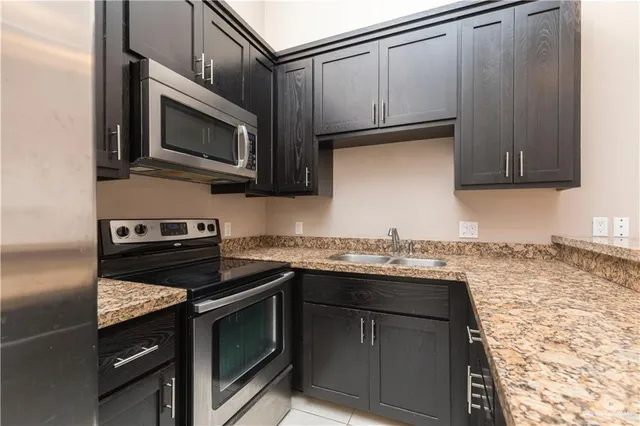 a kitchen with stainless steel appliances granite countertop a sink stove and microwave