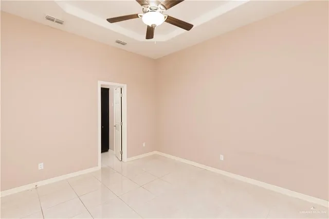 an empty room with a ceiling fan and a window