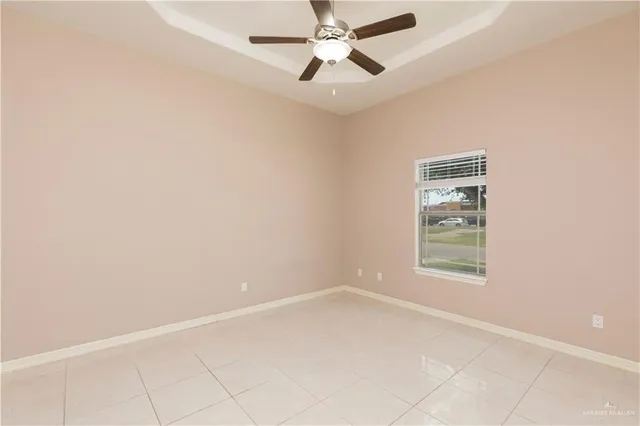 an empty room with a window and a fan