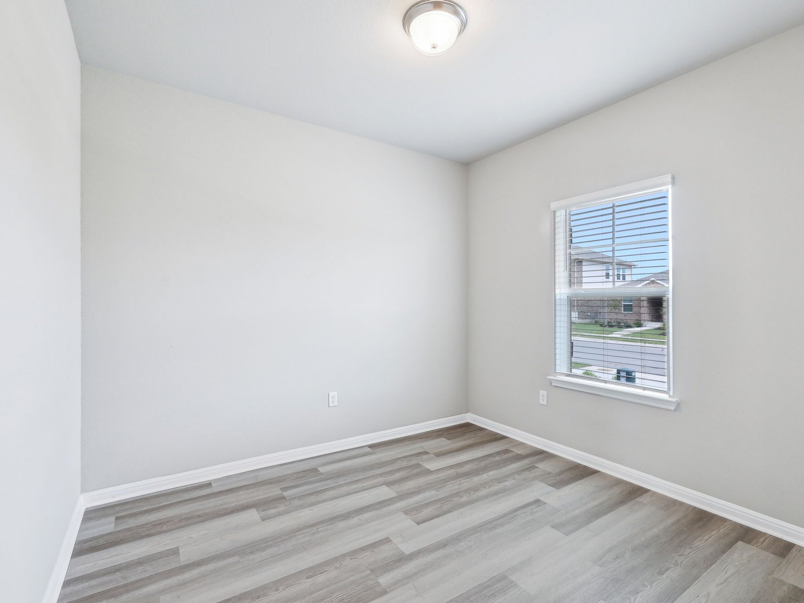 113 Maple Hedge Road Hutto, TX 78634 - Photo 17 of 20 a view of an empty room with wooden floor and a window