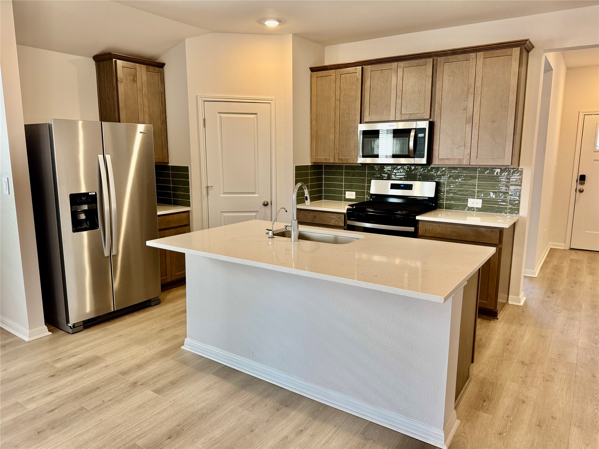 113 Maple Hedge Road Hutto, TX 78634 - Photo 2 of 20 a kitchen with stainless steel appliances a refrigerator a stove a sink a center island and a refrigerator