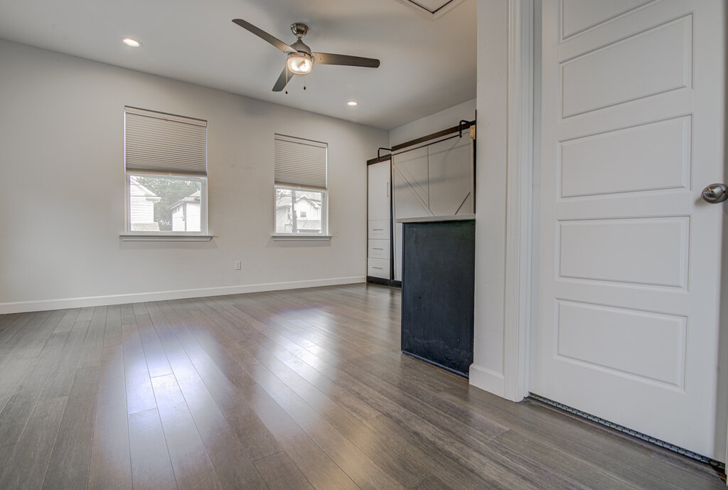 2406 East 16th Street Austin, TX 78702 - Photo 35 of 39 an empty room with wooden floor fireplace and windows